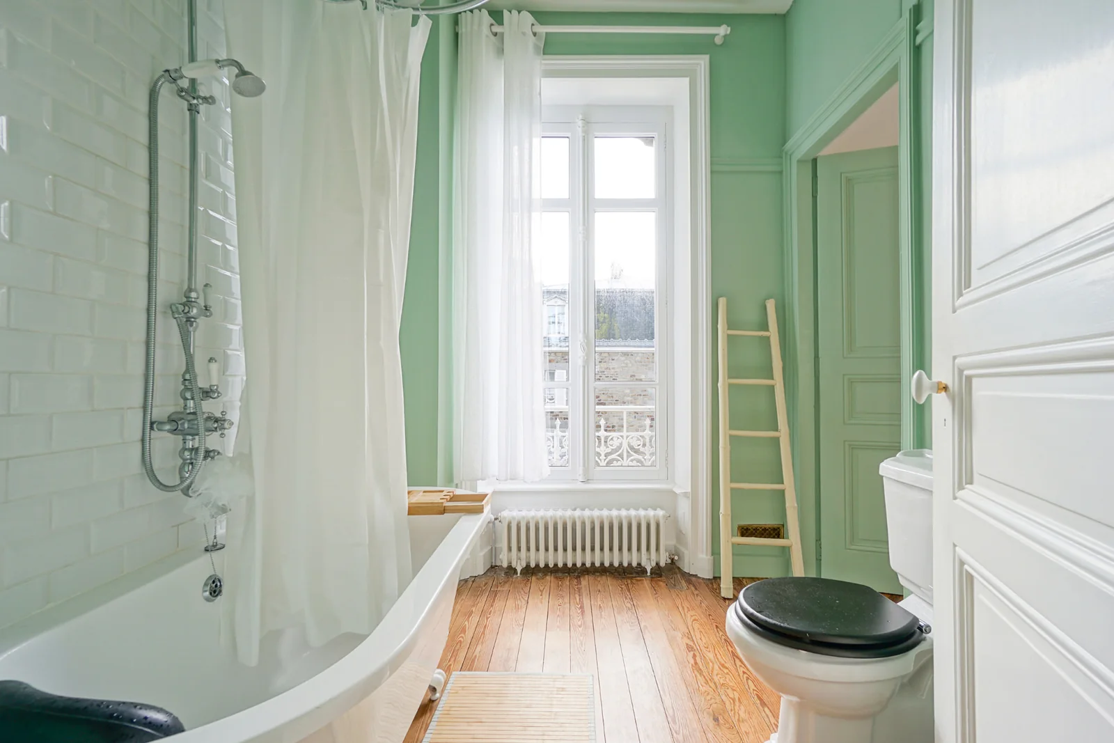 Green bathroom at Le Manoir Ducey with bathtub and shower