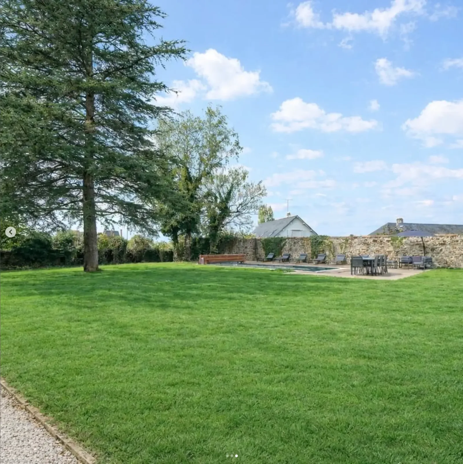 The lawn, cedar tree and swimming pool at Le Manoir Ducey