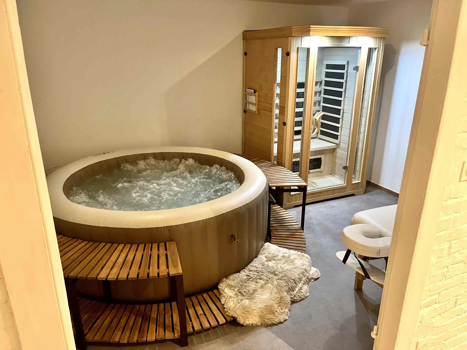 Spa room with jacuzzi, infrared sauna and massage table at Le Manoir Ducey